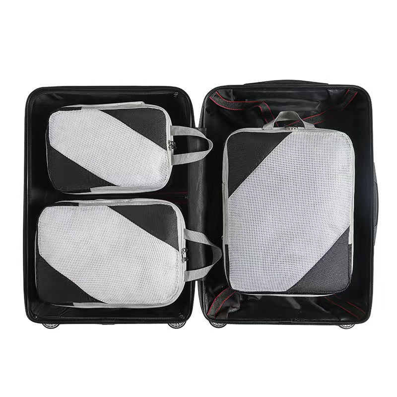 Three black packing cubes with mesh panels arranged in an open suitcase; suitcase not included.